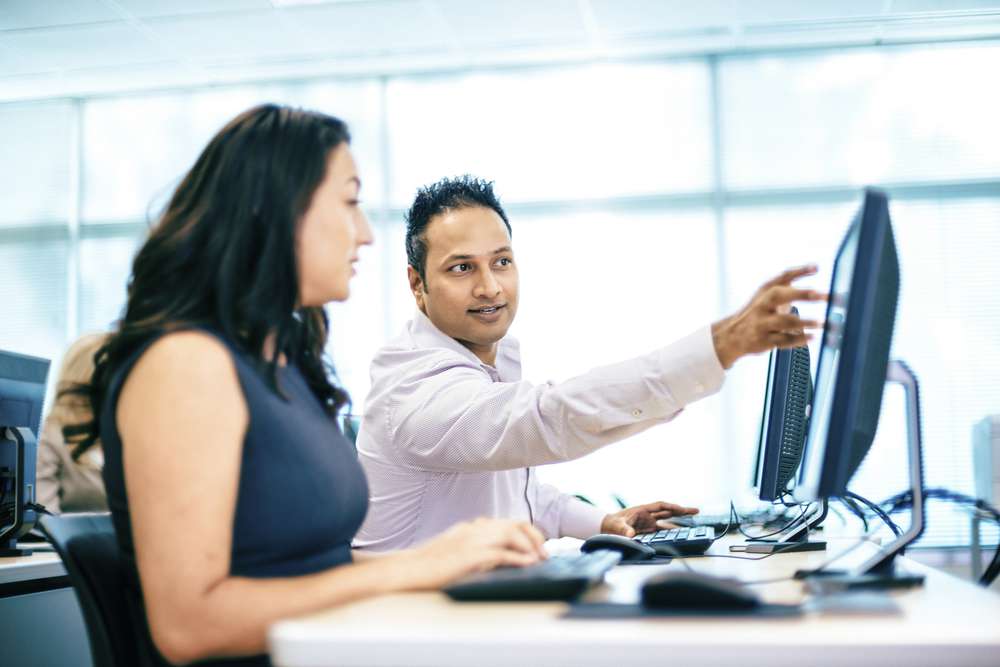 Two workers looking at screen iStock_30762560_MEDIUM