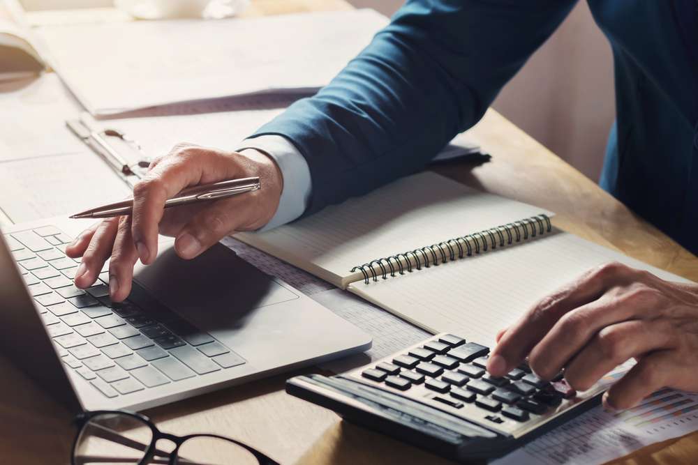 Businessman Workig Using Calculator With Laptop Desk